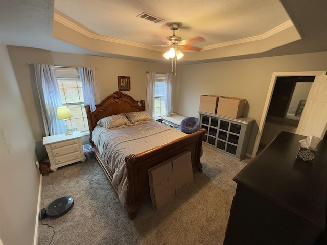 carpeted bedroom featuring crown molding, ceiling fan, and a tray ceiling