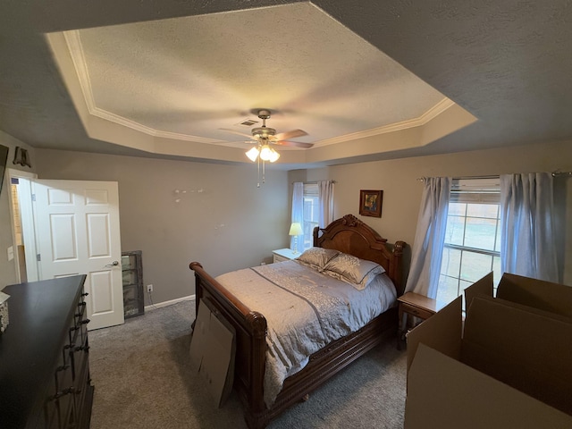 bedroom with ceiling fan, dark carpet, a raised ceiling, and a textured ceiling