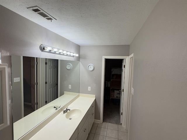 bathroom with tile patterned floors, vanity, and a textured ceiling