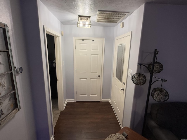 hallway featuring dark hardwood / wood-style flooring and a textured ceiling