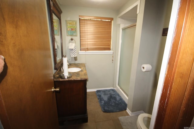 bathroom featuring vanity, toilet, an enclosed shower, and tile patterned flooring