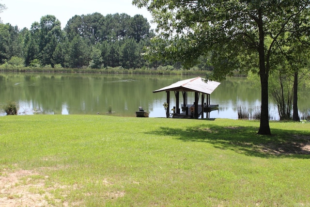 view of dock featuring a lawn and a water view