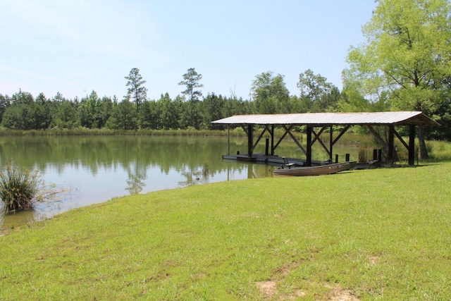 dock area with a lawn and a water view