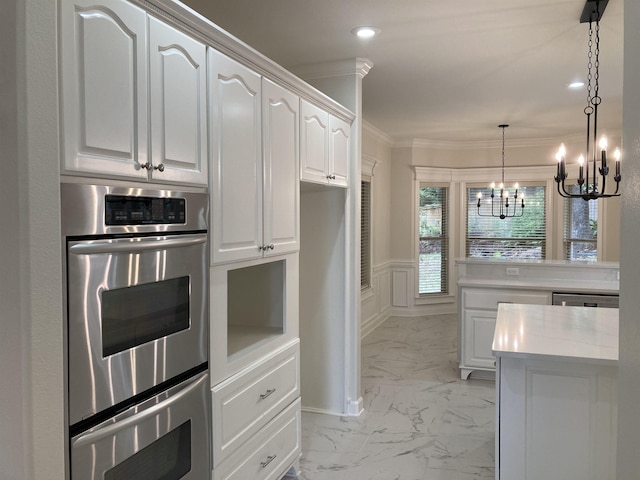 kitchen with white cabinetry, hanging light fixtures, ornamental molding, a notable chandelier, and stainless steel double oven