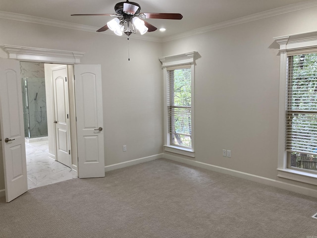 carpeted spare room featuring crown molding and ceiling fan