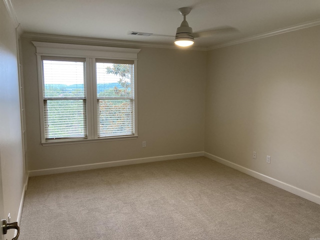 unfurnished room featuring ceiling fan, light colored carpet, and ornamental molding