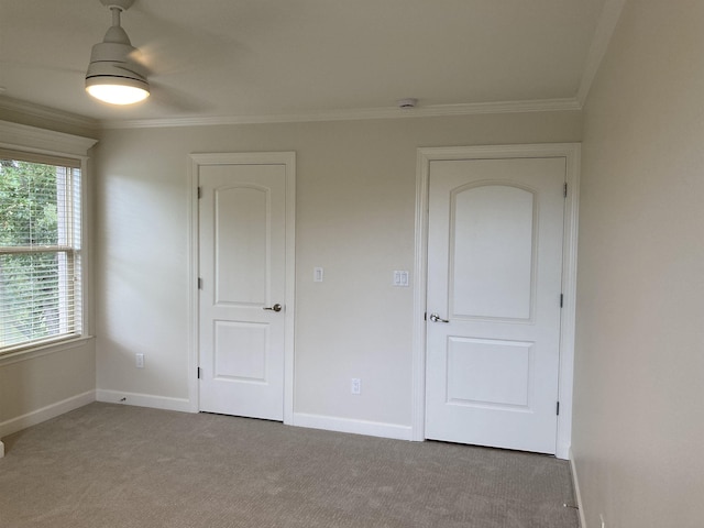 unfurnished bedroom with carpet floors, ornamental molding, and ceiling fan