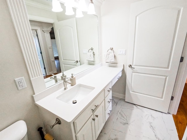 bathroom with crown molding, vanity, and toilet