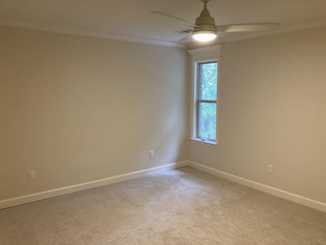 empty room featuring crown molding, light colored carpet, and ceiling fan