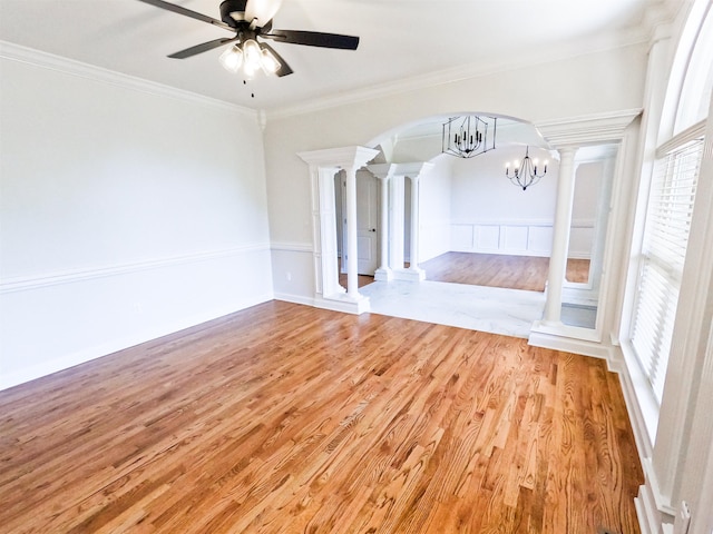 unfurnished living room with hardwood / wood-style floors, ceiling fan with notable chandelier, ornamental molding, and decorative columns