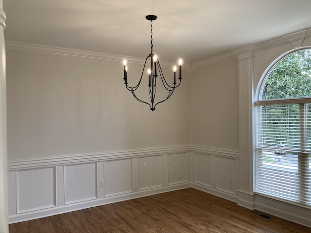 unfurnished room with an inviting chandelier, ornamental molding, and dark hardwood / wood-style floors