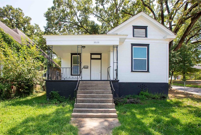 bungalow-style home featuring covered porch and a front lawn