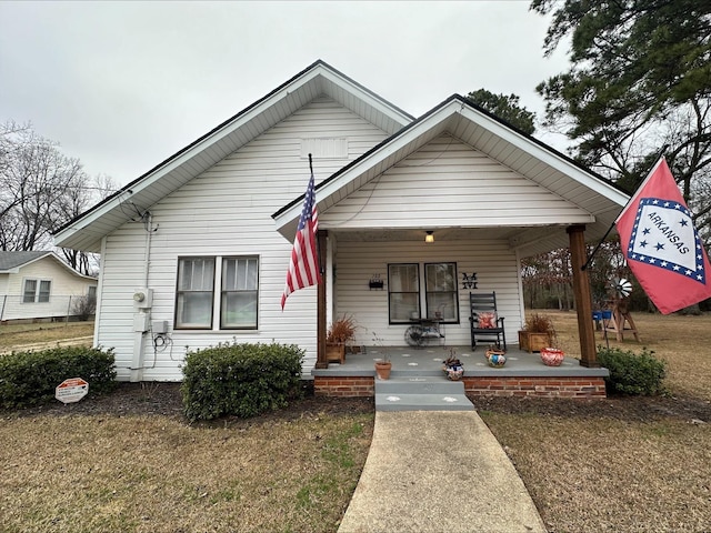 bungalow-style home with a front lawn and a porch