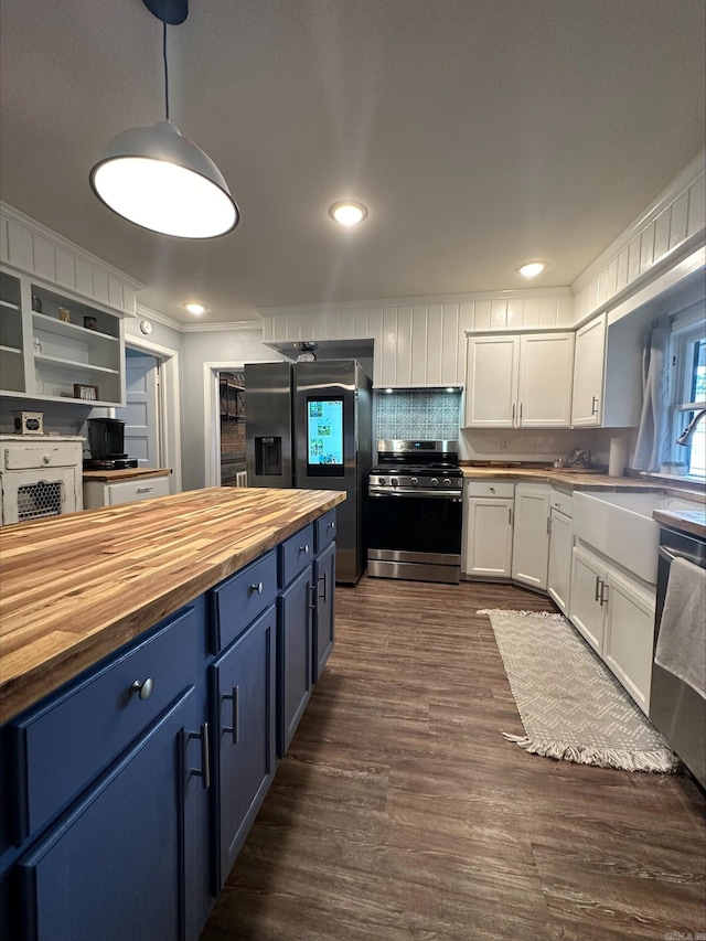 kitchen featuring appliances with stainless steel finishes, butcher block counters, hanging light fixtures, white cabinetry, and blue cabinets