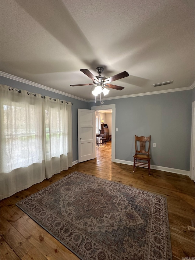 unfurnished room featuring crown molding, dark wood-type flooring, ceiling fan, and a textured ceiling