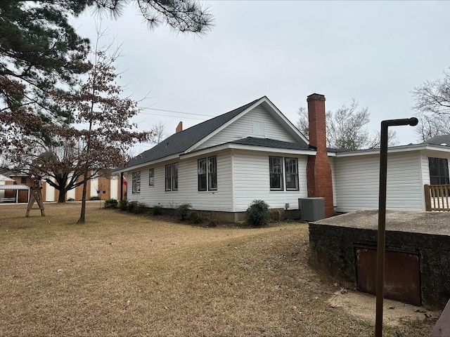 view of side of property with a lawn and central air condition unit