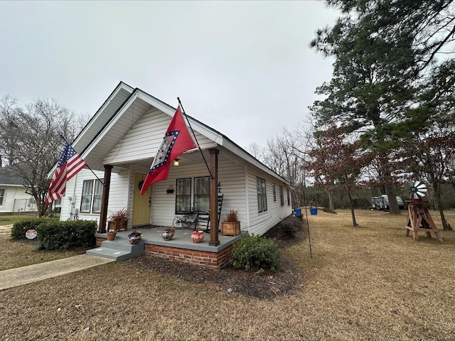 view of front of home with a porch and a front yard