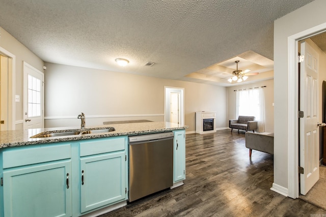 kitchen with sink, dark hardwood / wood-style flooring, a tray ceiling, dishwasher, and ceiling fan