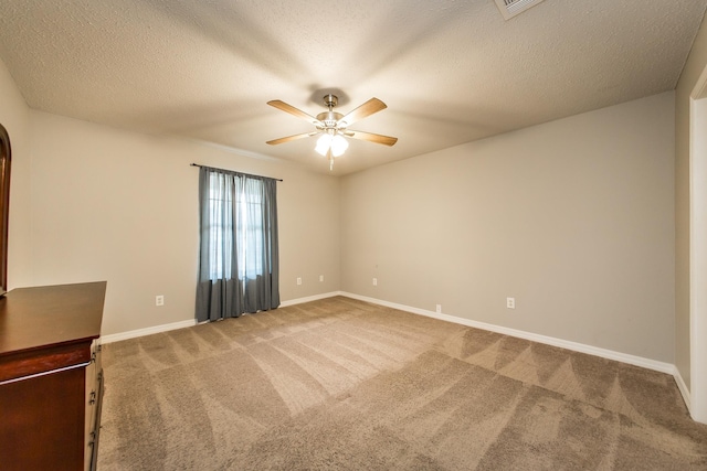 carpeted spare room featuring ceiling fan and a textured ceiling