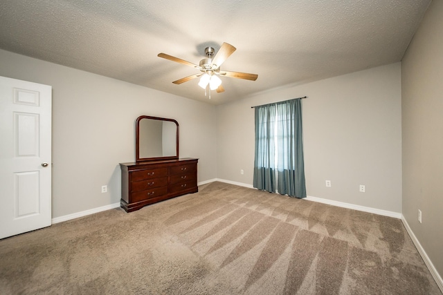 unfurnished bedroom with ceiling fan, carpet, and a textured ceiling