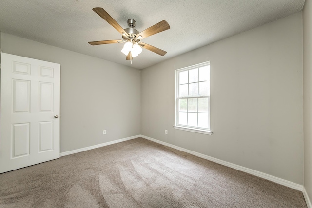 empty room featuring ceiling fan, carpet, and a textured ceiling