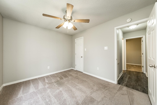 carpeted empty room featuring ceiling fan and a textured ceiling