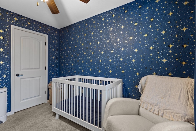 bedroom featuring a crib, carpet floors, and ceiling fan