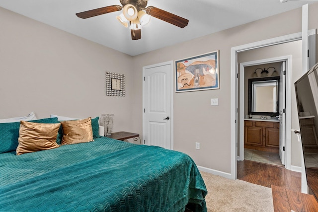 bedroom with connected bathroom, dark wood-type flooring, and ceiling fan