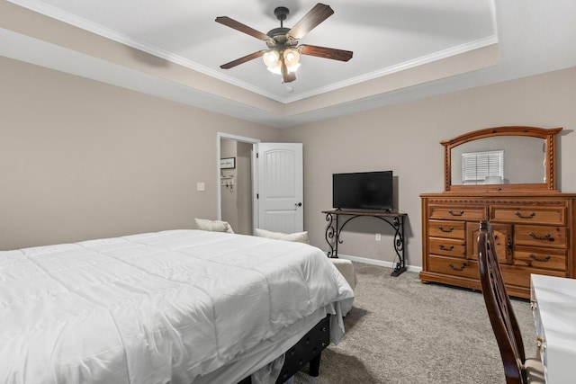 bedroom with a tray ceiling, ornamental molding, ceiling fan, and carpet