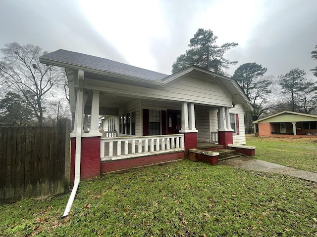 bungalow-style home with covered porch and a front lawn