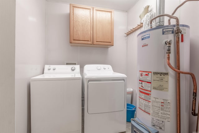 laundry room featuring cabinets, washing machine and dryer, and water heater