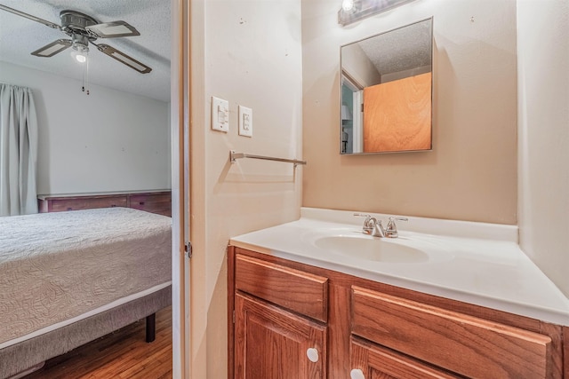 bathroom featuring vanity, ceiling fan, and a textured ceiling