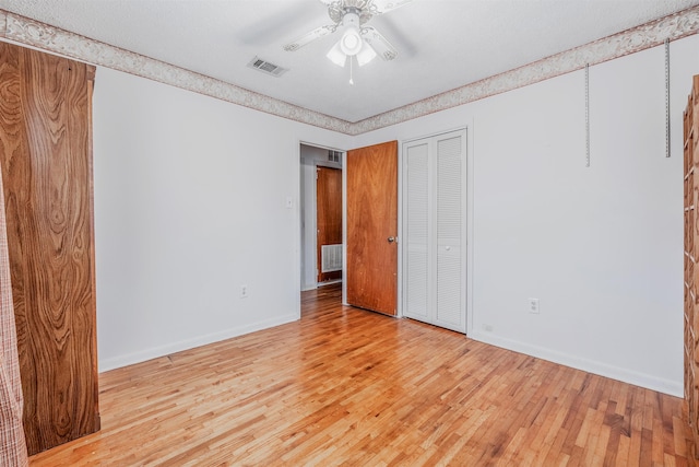 unfurnished bedroom featuring light hardwood / wood-style floors, a closet, and ceiling fan