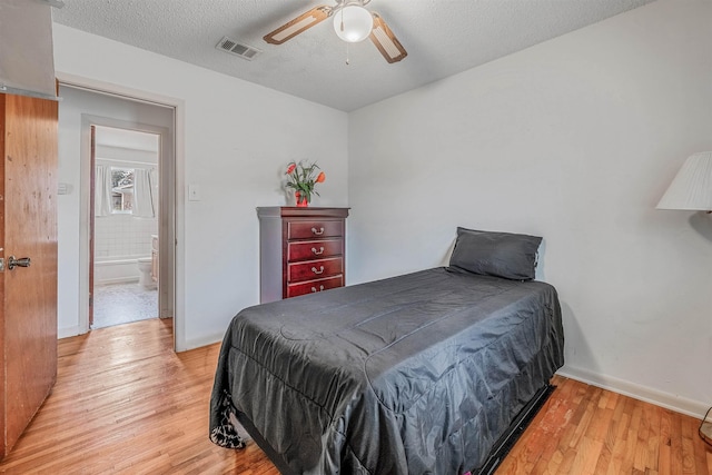 bedroom featuring ceiling fan, hardwood / wood-style floors, and a textured ceiling