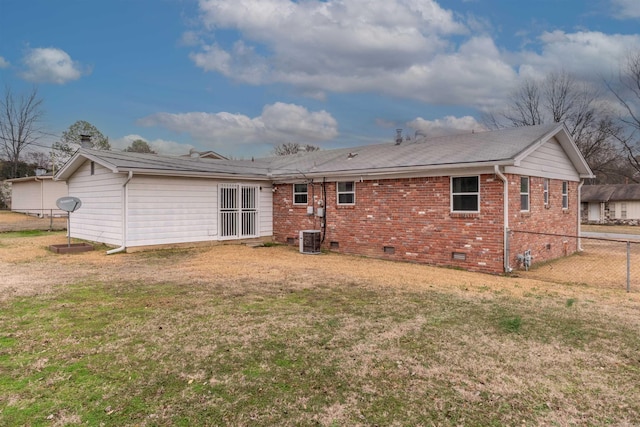 rear view of house with cooling unit and a yard