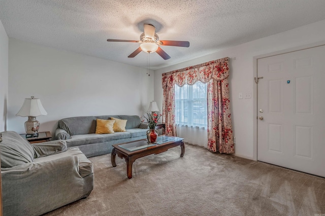 living room with ceiling fan, carpet floors, and a textured ceiling