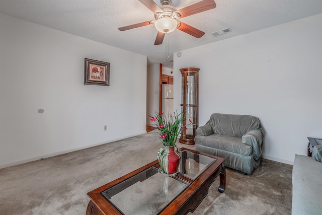 carpeted living room with ceiling fan and a textured ceiling