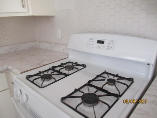 details featuring white gas range and white cabinets