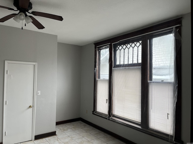 tiled empty room with ceiling fan