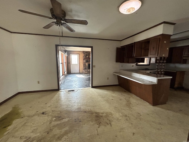 kitchen featuring dark brown cabinetry, crown molding, kitchen peninsula, and ceiling fan