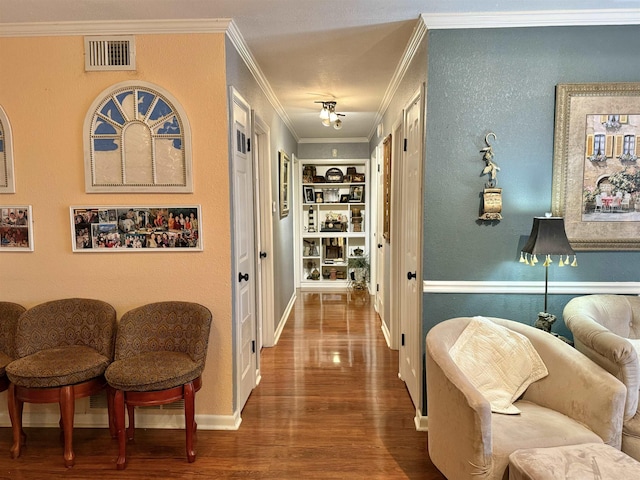 hall featuring crown molding, built in shelves, and wood-type flooring