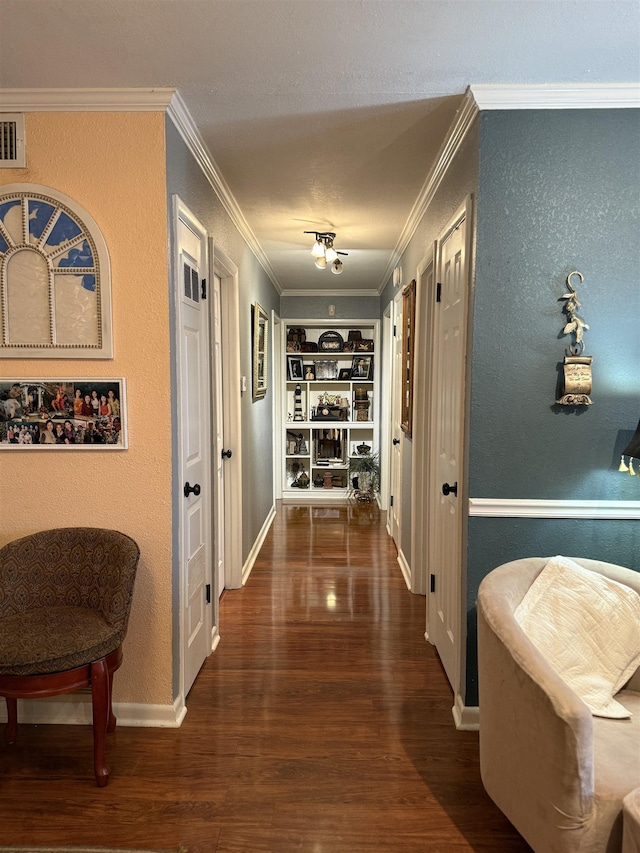 hall with dark hardwood / wood-style flooring, crown molding, and built in shelves