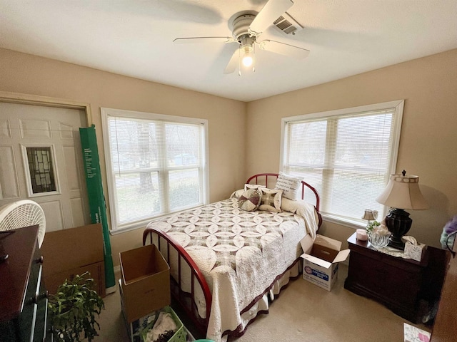 carpeted bedroom with multiple windows and ceiling fan