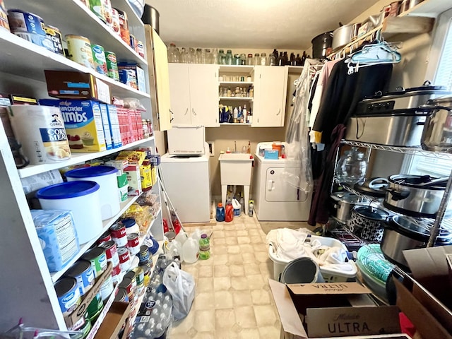 laundry area featuring washer / clothes dryer, sink, and cabinets