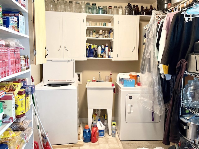 clothes washing area featuring independent washer and dryer and cabinets