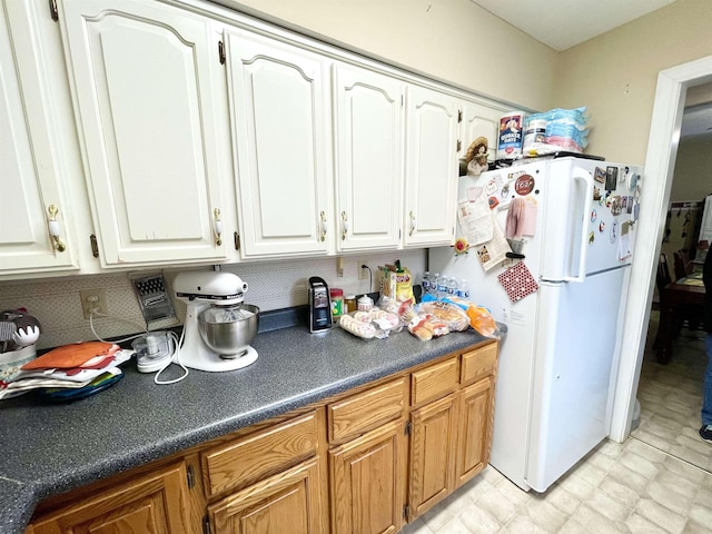 kitchen featuring white cabinetry and white fridge