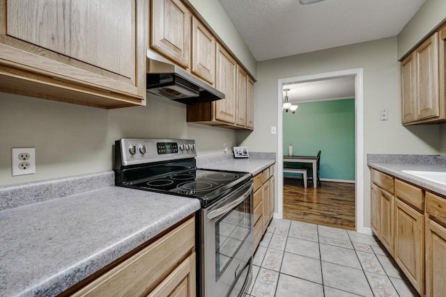 kitchen featuring electric stove, light tile patterned floors, decorative light fixtures, a chandelier, and light brown cabinets