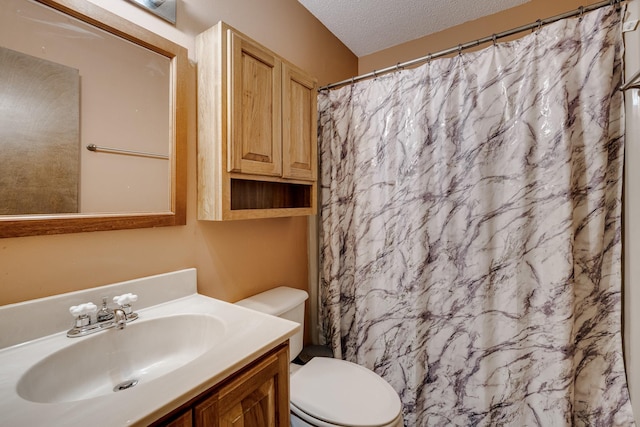 bathroom featuring vanity, toilet, a shower with shower curtain, and a textured ceiling