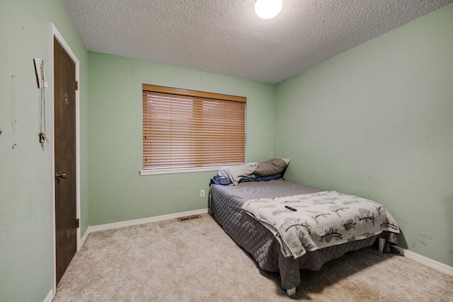 carpeted bedroom featuring a textured ceiling