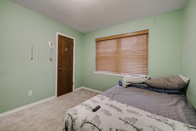 bedroom featuring light carpet and a textured ceiling